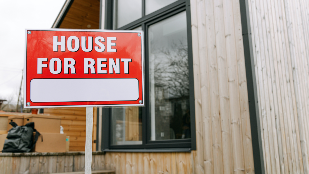 House with a for rent sign in the yard